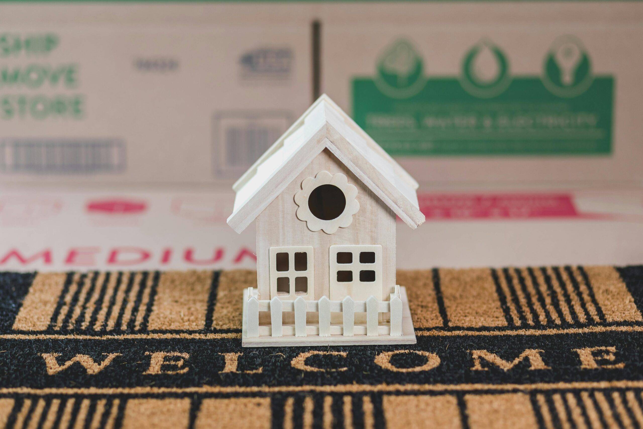 Small wooden toy house representing downsizing your home in Laguna Hills for empty nesters and retirees