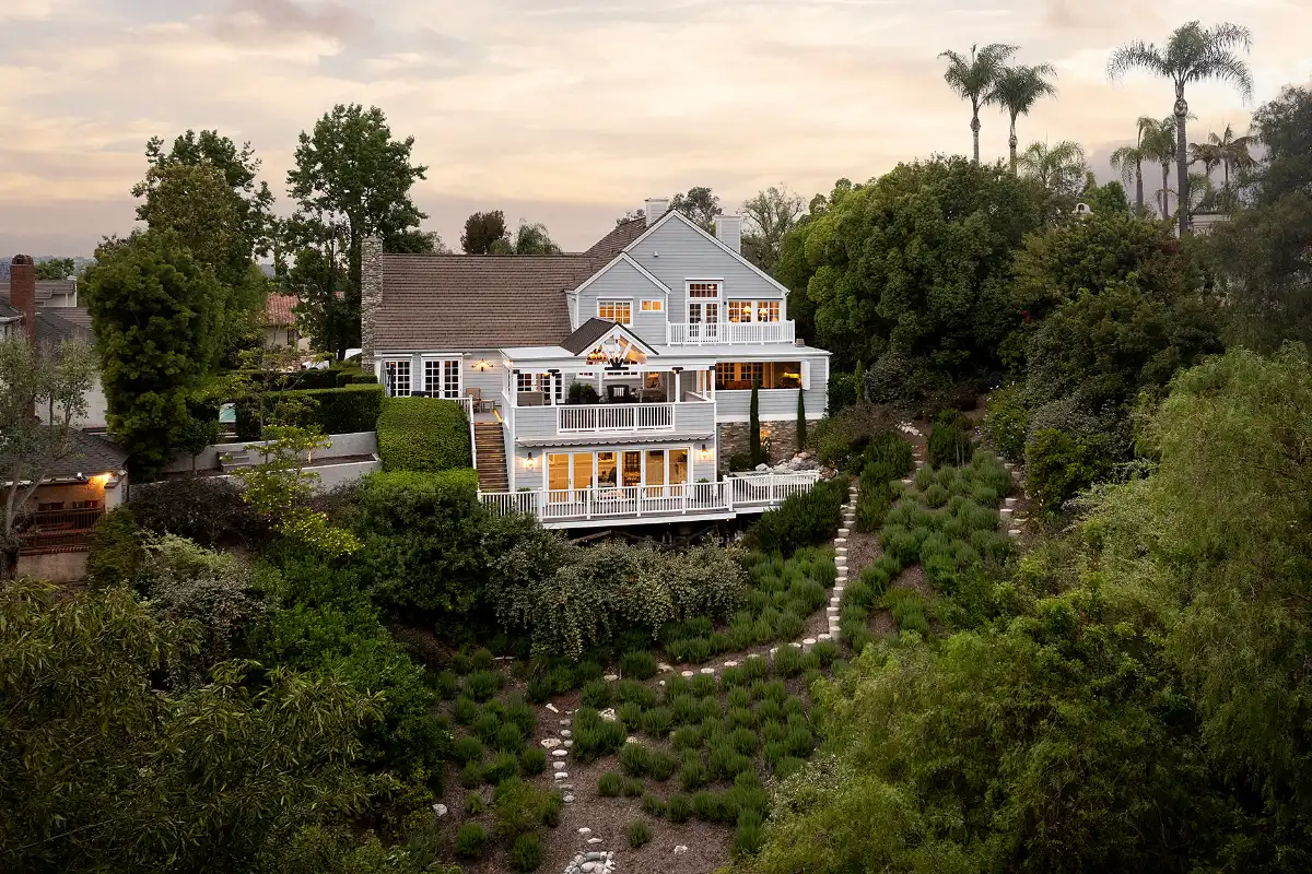 Drone photo of luxury home backyard with path through lush springtime landscape