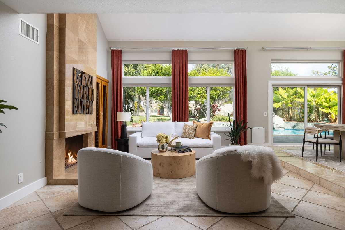 Living room of a luxury home with large fireplace and backyard views, polished presentation for listing and staging and selling your Orange County home with top real estate agents