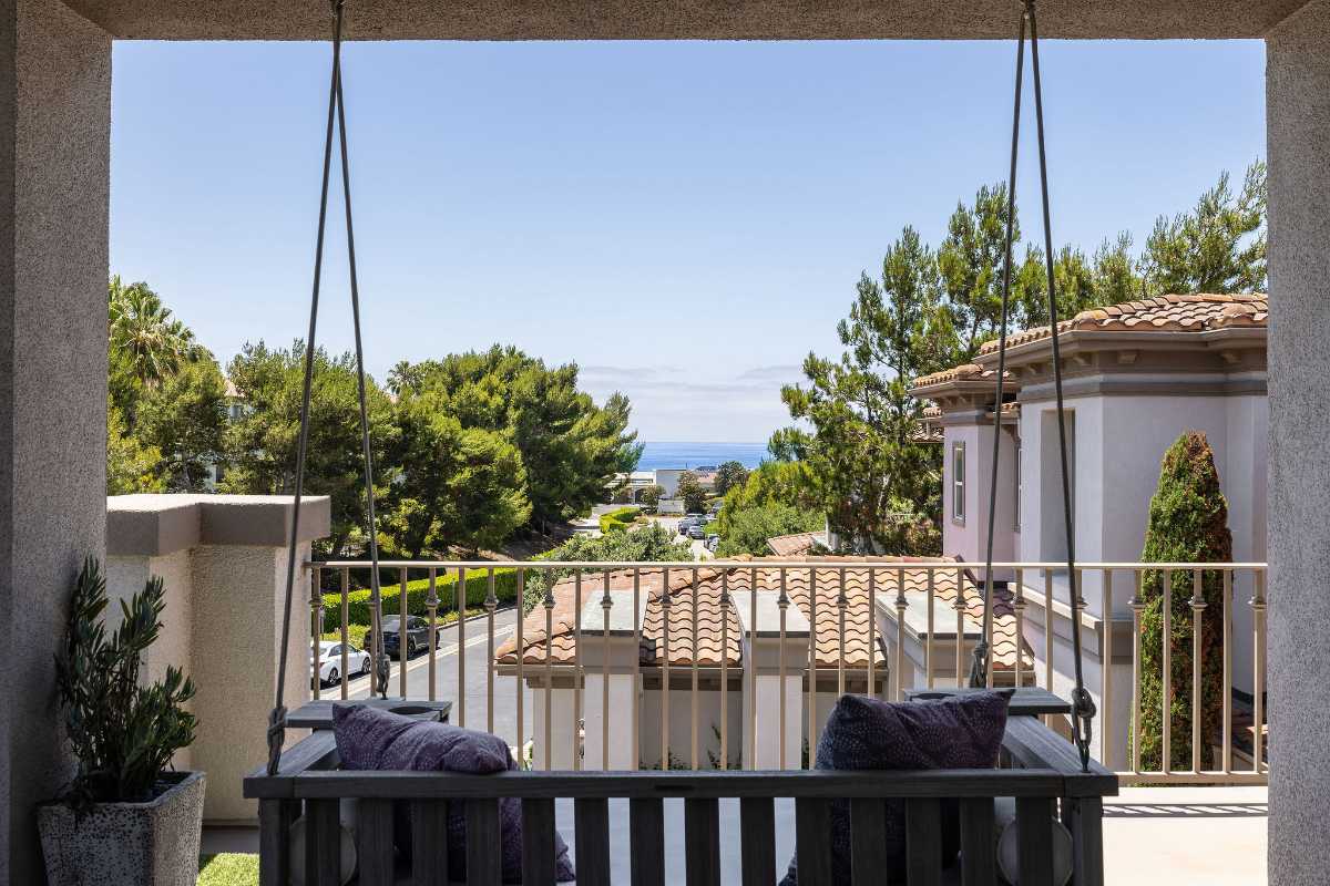 Outdoor living area with swing seat overlooking Dana Point and the ocean beyond